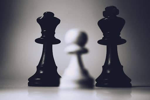 Three chess pieces on a white table symbolizing a digital marketing strategy Fix and Form Strategic Branding Agency, Denver Colorado