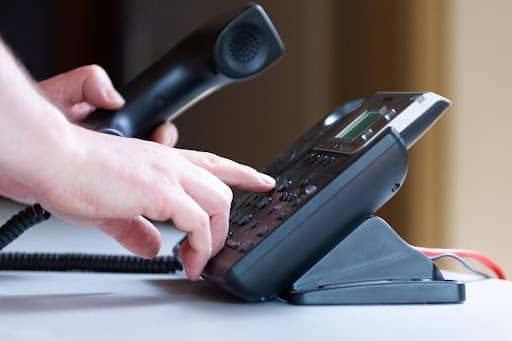Close up of a hand dialing an analog phone symbolizing a customer calling for products or services Fix and Form strategic branding agency Denver Colorado