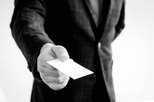 Man handing the camera a blank business card representing the role naming has in your brand management Fix and Form Strategic Branding Denver Colorado