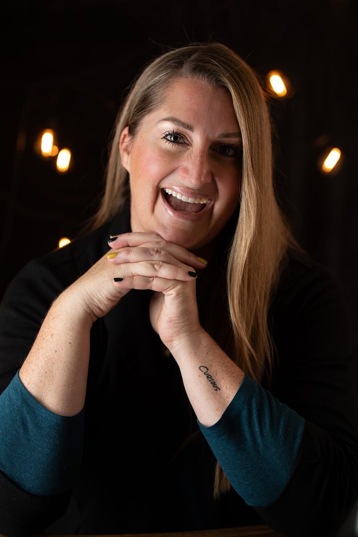 Anne Gillaspie laughing with light bulbs in the background welcoming fix & form strategic branding agency denver colorado